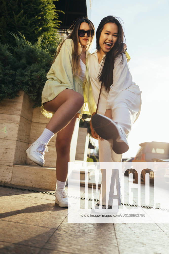 Happy friends standing on footpath model released Symbolfoto OYF00535