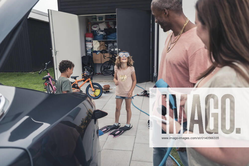 IMAGO Creative: Corporate: Klimaschutz, Digitalisierung und Urbanisierung Parents looking at daughter wearing swimming goggles in front yard Sweden, Skane, model released, property released