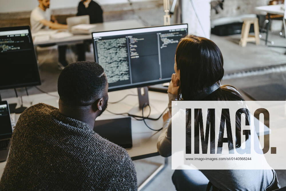 Male and female programmers coding over computer in creative office Germany, Berlin, model released, property released
