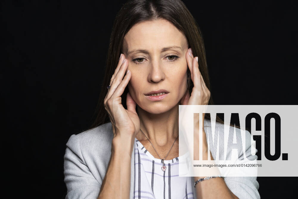 Thoughtful mature woman with her head in hands