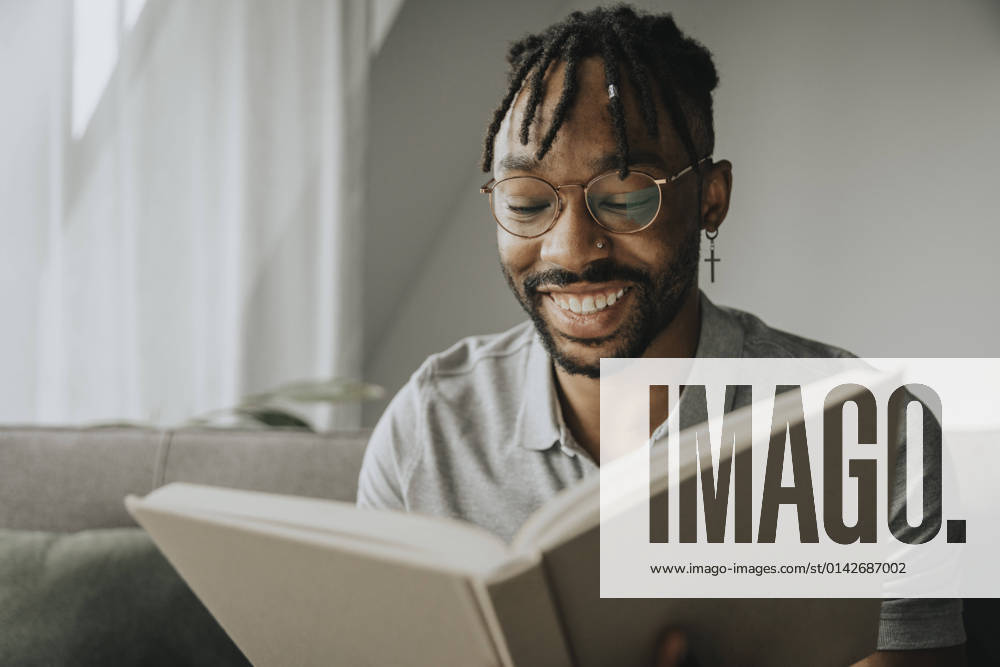Happy man with eyeglasses reading book at home model released property released, MFF08303