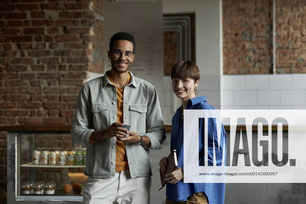 IMAGO Creative: Gesellschaft, Integration Smiling couple standing in modern cafe model released property released, DSHF00088