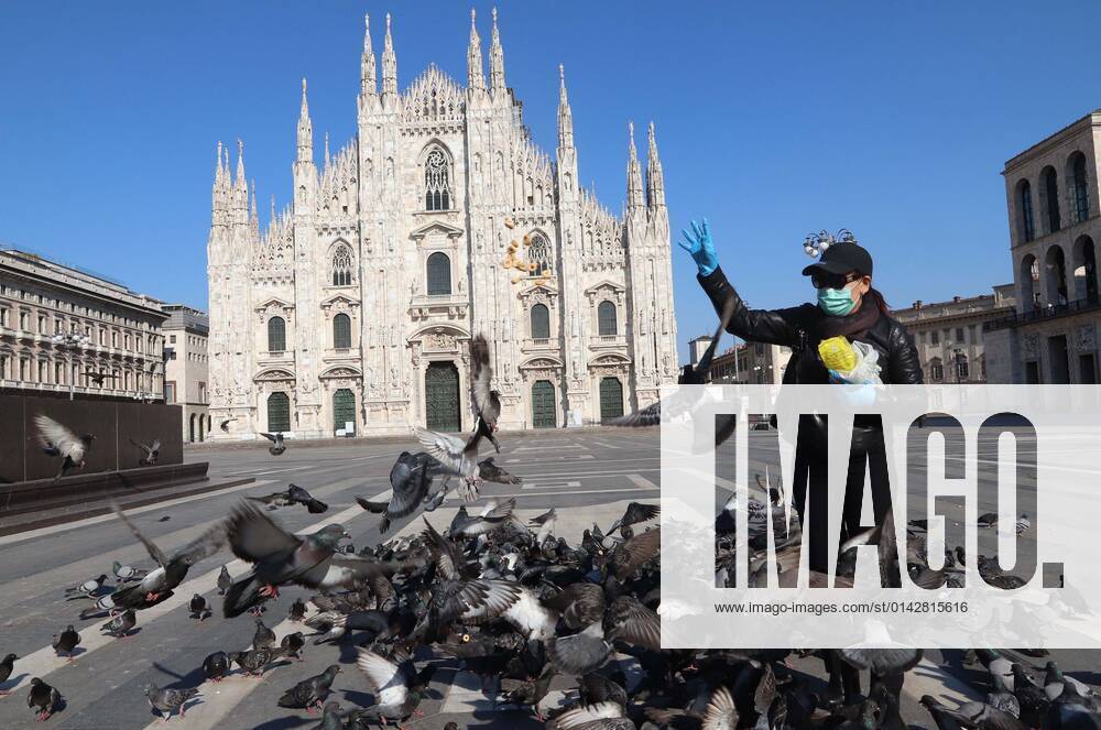 Foto ipp-giorgio rossi- milano 10 04 2020- emergenza coronavirus -piazza duomo deserta e piccioni vengono sfamati da una ragazza con mascherina emergenza coronavirus -piazza du
