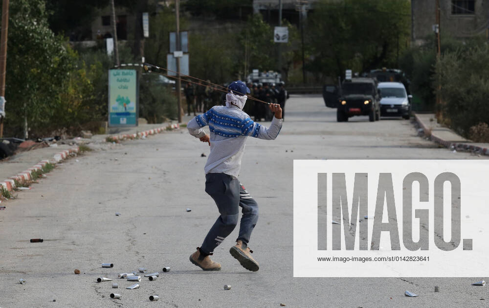 (211125) -- NABLUS, Nov. 25, 2021 -- A protester uses a slingshot to hurl a stone at members of the Israeli border police during clashes in the village of al-Lubban al-Sharqiya near the West Bank city of Nablus, on Nov. 25, 2021. (Photo by Xinhua) MIDEAST-NABLUS-CLASHES NidalxEshtayeh