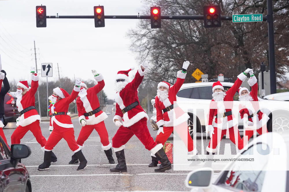 USA, DJ Reggie and the Hip Hop Mamas alias Dancing Santas in Frontenac, Missouri DJ Reggie and the Hip Hop Mamas, known as the Dancing Santas entertain drivers at the red light in Frontenac, Missouri on Tuesday, December 7, 2021. The Dancing Santas entertain holiday shoppers throughout the area, dancing in the streets, collecting money for various charities. SLP2021120702 BILLxGREENBLATT
