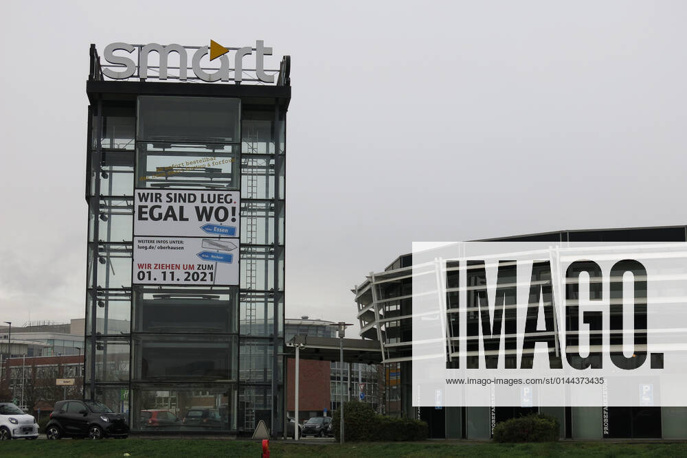 Geschlossenes Autohaus Smart Center. Der charakteristische Turm Tower Glasturm (das Smart Center Oberhausen war 1998 weltweit das Erste) mit Smart Schriftzug Logo ist bereits leer (mit Hinweis auf die Schliessung zum 01.11.2021 bzw. Umzug zu bestehenden Standorten der Fahrzeug-Werke Lueg in Bochum und Essen), vereinzelt stehen auf dem Gelände noch einige Neuwagen (Smart fortwo forfour). Smart Automobile ist seit 2020 ein Gemeinschaftsunternehmen von Mercedes Benz (Daimler) und Geely (Zhejiang Geely Holding Group).