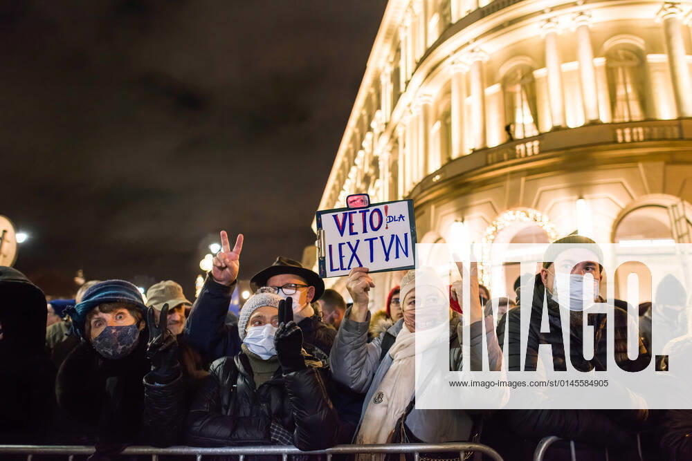 Demonstrators gesture and hold a placard during the protest..Thousands of people came to the presidential palace in Warsaw to protest against restrictions of media freedom by the Polish government. On Friday 17th of December a bill to restrict foreign ownership of Polish media was unexpectedly passed by the Polish parliament. The proposed law is seen to be aimed in particular at Polands largest private broadcaster US-owned TVN, whose coverage is often critical of the government and is seen by many as a TV station that defends freedom of speech. The bill (called Lex TVN) now heads to the president, Andrzej Duda, who must decide whether to sign it into law. If he does so, it could pro - ZUMAs197 20211219_zaa_s197_239