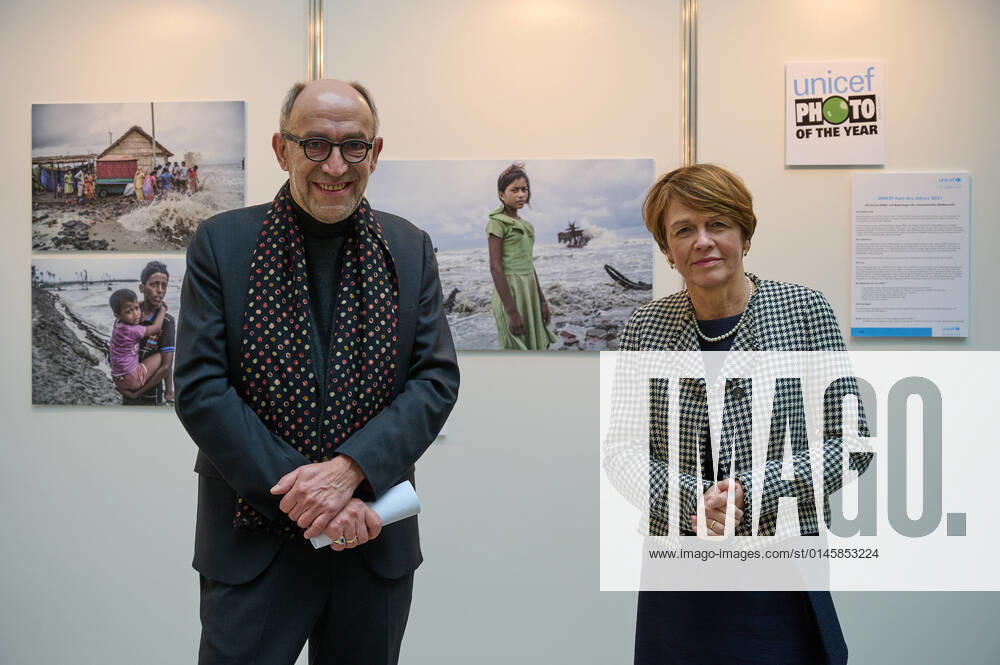 Unicef-Schirmherrin Elke Buedenbender und Peter-Matthias Gaede, Unicef-Vorstand, vor dem Unicef-Foto des Jahres 2021 in der Ausstellung im Haus der Bundespressekonferenz in Berlin (Foto vom 21.12.2021). Das Siegerfoto des indischen Fotografen Supratim Bhattacharjee aus den indischen Sundarbans zeigt ein elfjaehriges indisches Maedchen, dessen Teeausschank von einem verheerenden Wirbelsturm auf das offene Meer gefegt wurde. (Siehe epd-Meldung vom 21.12.2021) Unicef-Foto des Jahres zeigt indisches Maedchen vor verwuesteter Kueste