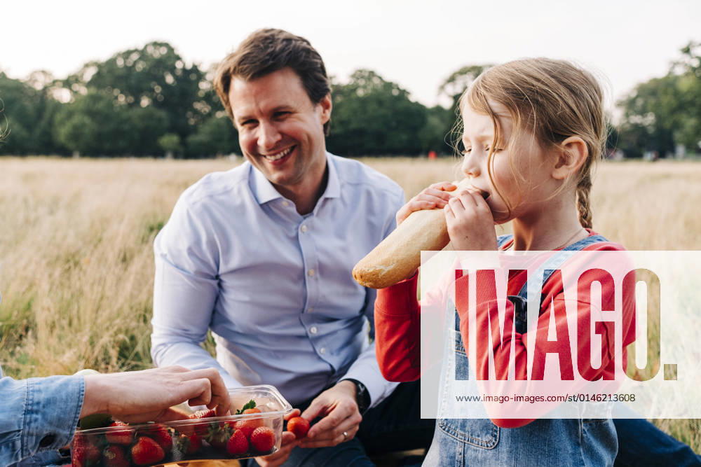 Girl eating loaf of bread at picnic with family in park model released, ASGF01675