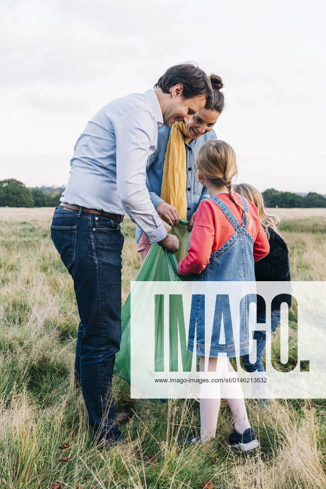 IMAGO Creative: Jahreszeit Frühling, Picknick Family collecting garbage in plastic bag after picnic at park model released, ASGF01699