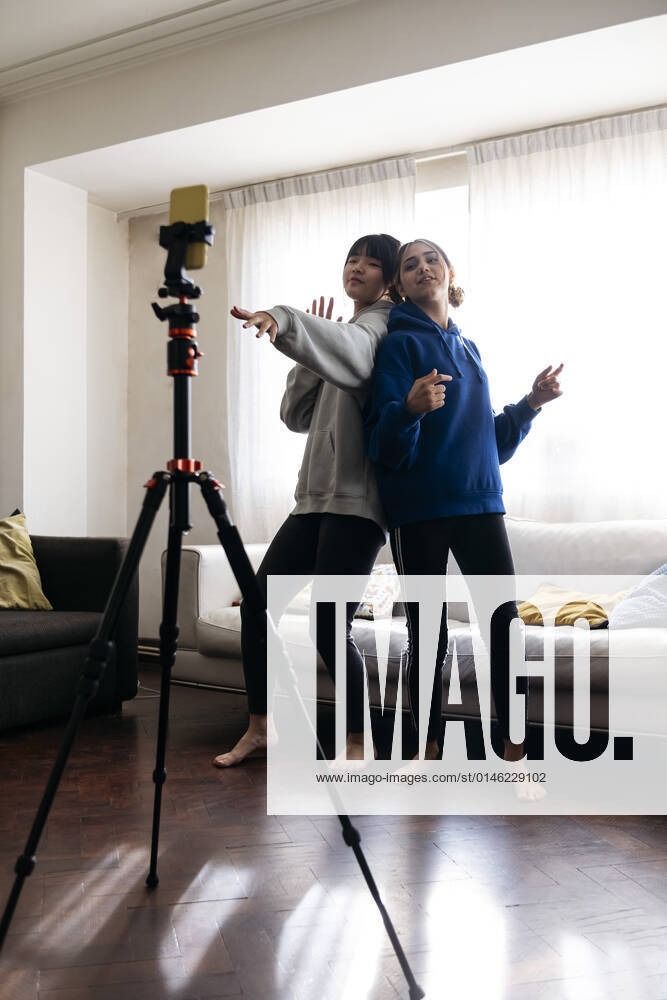 Friends filming dance through mobile phone at home model released property released, ASGF01907