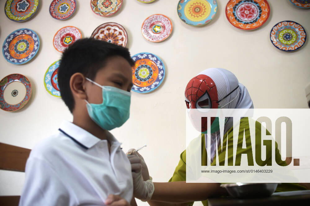 (211229) -- JAKARTA, Dec. 29, 2021 -- A medical worker wearing a superhero character mask administers a dose of COVID-19 vaccine to a child during vaccination for children aged 6 to 11 at RSIA Tambak Hospital in Jakarta, Indonesia, Dec. 29, 2021. ) INDONESIA-JAKARTA-COVID-19-CHILDREN-VACCINATION Zulkarnain