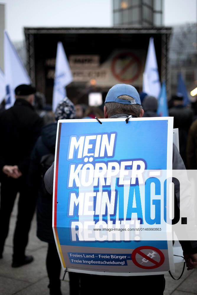 Protest AfD - Gegen Impfplicht DEU, Deutschland, Germany, Berlin, 11.12.2021 Demonstrant mit Plakat Mein Koerper Mein Recht Freies Land Freie Impfentscheidung vor Transparent Die Jugend Steht Auf Telegram Impfstreik auf einer Kundgebung und Demonstration der Jungen Alternative JA, die Jugendorganisation‹ der rechtsextremen Partei Alternative fuer Deutschland AfD gegen eine Impfpflicht und die Coronapolitik der Bundesregierung unter dem Motto Impfstreik Deutschland im Regierungsviertel in Berlin. Der Protest ist gegen das Impfen gegen Corona Covid-19 und eine moegliche Impfpflicht wird unterstuetzt von sog. Querdenker und Rechtsradikalen. Junge Alternative fuer Deutschland. en: Protester with poster Mein Koerper Mein Recht Free Land Free v