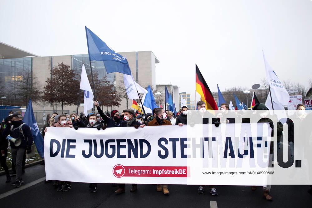 Protest AfD - Gegen Impfplicht DEU, Deutschland, Germany, Berlin, 11.12.2021 Demonstrant mit Transparent Die Jugend Steht Auf Telegram Impfstreik auf einer Kundgebung und Demonstration der Jungen Alternative JA, die Jugendorganisation‹ der rechtsextremen Partei Alternative fuer Deutschland AfD gegen eine Impfpflicht und die Coronapolitik der Bundesregierung unter dem Motto Impfstreik Deutschland vor dem Bundeskanzleramt im Regierungsviertel in Berlin. Der Protest ist gegen das Impfen gegen Corona Covid-19 und eine moegliche Impfpflicht wird unterstuetzt von sog. Querdenker und Rechtsradikalen. Junge Alternative fuer Deutschland. en: Protester with banner The youth stands up on Telegram vaccination strike at a rally and demonstration by th