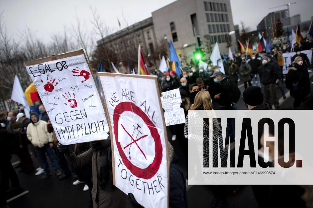 Protest AfD - Gegen Impfplicht DEU, Deutschland, Germany, Berlin, 11.12.2021 Demonstrant mit Plakat We Are All Together Symbol Spritze Gegen Impfpflicht auf einer Kundgebung und Demonstration der Jungen Alternative JA, die JugendorganisationöÄa der rechtsextremen Partei Alternative fuer Deutschland AfD gegen eine Impfpflicht und die Coronapolitik der Bundesregierung unter dem Motto Impfstreik Deutschland im Regierungsviertel in Berlin. Der Protest ist gegen das Impfen gegen Corona Covid-19 und eine moegliche Impfpflicht wird unterstuetzt von sog. Querdenker und Rechtsradikalen. Junge Alternative fuer Deutschland. en: Protester with poster We are all together symbol syringe against mandatory vaccination at a rally and demonstration by th