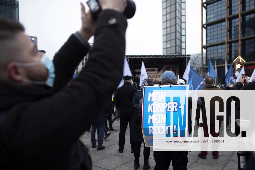 Protest AfD - Gegen Impfplicht DEU, Deutschland, Germany, Berlin, 11.12.2021 Demonstrant mit Plakat Mein Koerper Mein Recht Freies Land Freie Impfentscheidung vor Transparent Die Jugend Steht Auf Telegram Impfstreik auf einer Kundgebung und Demonstration der Jungen Alternative JA, die Jugendorganisation‹ der rechtsextremen Partei Alternative fuer Deutschland AfD gegen eine Impfpflicht und die Coronapolitik der Bundesregierung unter dem Motto Impfstreik Deutschland im Regierungsviertel in Berlin. Der Protest ist gegen das Impfen gegen Corona Covid-19 und eine moegliche Impfpflicht wird unterstuetzt von sog. Querdenker und Rechtsradikalen. Junge Alternative fuer Deutschland. en: Protester with poster Mein Koerper Mein Recht Free Land Free v
