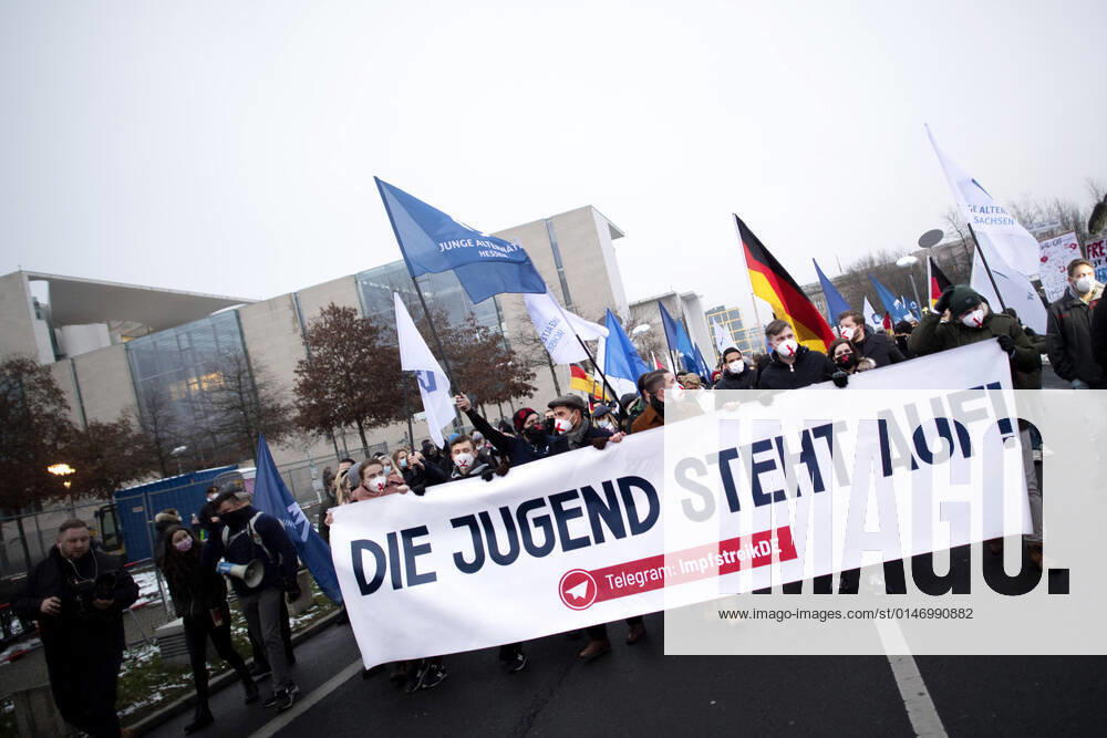 Protest AfD - Gegen Impfplicht DEU, Deutschland, Germany, Berlin, 11.12.2021 Demonstrant mit Transparent Die Jugend Steht Auf Telegram Impfstreik auf einer Kundgebung und Demonstration der Jungen Alternative JA, die Jugendorganisation‹ der rechtsextremen Partei Alternative fuer Deutschland AfD gegen eine Impfpflicht und die Coronapolitik der Bundesregierung unter dem Motto Impfstreik Deutschland vor dem Bundeskanzleramt im Regierungsviertel in Berlin. Der Protest ist gegen das Impfen gegen Corona Covid-19 und eine moegliche Impfpflicht wird unterstuetzt von sog. Querdenker und Rechtsradikalen. Junge Alternative fuer Deutschland. en: Protester with banner The youth stands up on Telegram vaccination strike at a rally and demonstration by th