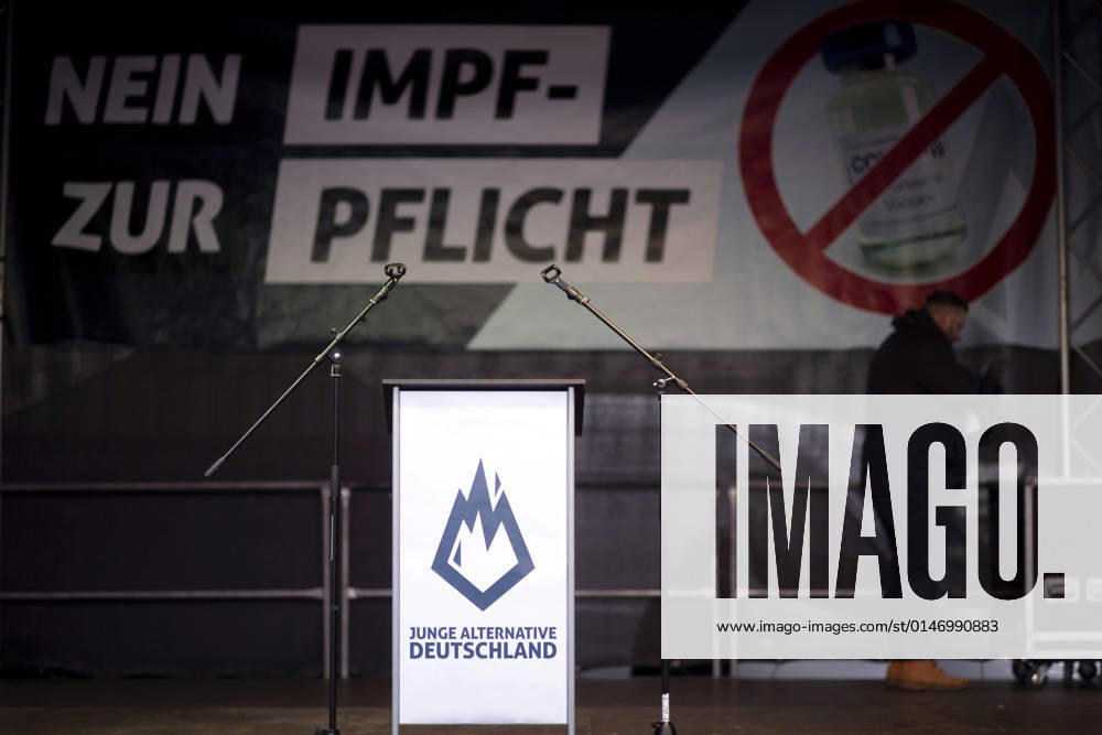 Protest AfD - Gegen Impfplicht DEU, Deutschland, Germany, Berlin, 11.12.2021 Podium mit Logo Flamme der Jungen Alternativen und Nein zur Impfpflicht auf einer Kundgebung und Demonstration der Jungen Alternative JA, die Jugendorganisation‹ der rechtsextremen Partei Alternative fuer Deutschland AfD gegen eine Impfpflicht und die Coronapolitik der Bundesregierung unter dem Motto Impfstreik Deutschland im Regierungsviertel in Berlin. Der Protest ist gegen das Impfen gegen Corona Covid-19 und eine moegliche Impfpflicht wird unterstuetzt von sog. Querdenker und Rechtsradikalen. Junge Alternative fuer Deutschland. en: Podium with the Flamme der Junge alternatives and no to mandatory vaccination at a rally and demonstration by the Junge Alternati