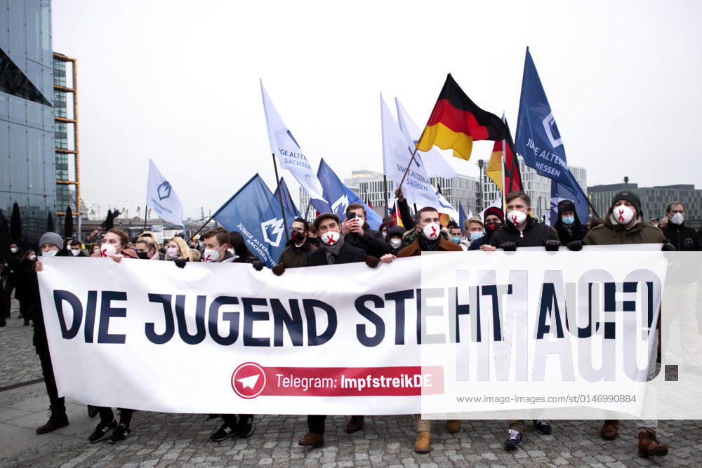 Protest AfD - Gegen Impfplicht DEU, Deutschland, Germany, Berlin, 11.12.2021 Demonstrant mit Transparent Die Jugend Steht Auf Telegram Impfstreik auf einer Kundgebung und Demonstration der Jungen Alternative JA, die Jugendorganisation‹ der rechtsextremen Partei Alternative fuer Deutschland AfD gegen eine Impfpflicht und die Coronapolitik der Bundesregierung unter dem Motto Impfstreik Deutschland im Regierungsviertel in Berlin. Der Protest ist gegen das Impfen gegen Corona Covid-19 und eine moegliche Impfpflicht wird unterstuetzt von sog. Querdenker und Rechtsradikalen. Junge Alternative fuer Deutschland. en: Protester with banner The youth stands up on Telegram vaccination strike at a rally and demonstration by the Junge Alternative JA, t