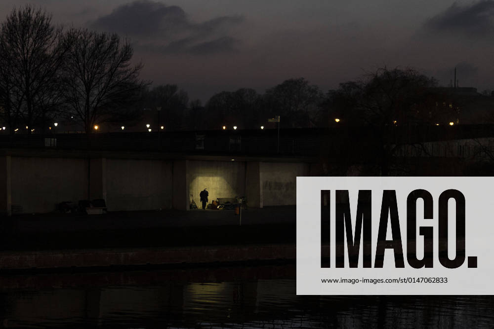 IMAGO Creative: Gesellschaft, Armut Ein Obdachloser zeichnet sich ab als Silhouette am Spreeufer in Berlin, 11.01.2022. Berlin Deutschland