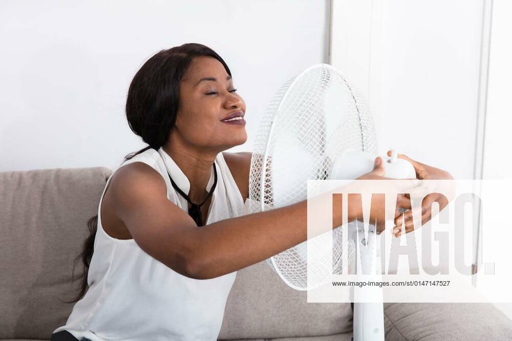 Woman Enjoying Breeze With Electric Fan model released, Symbolfoto, 25.09.2021,