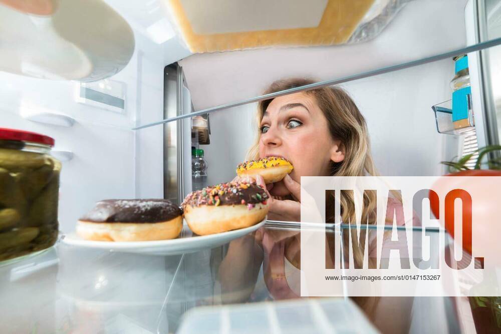 Happy Woman Eating Donut From Plate model released, Symbolfoto, 25.09.2021,