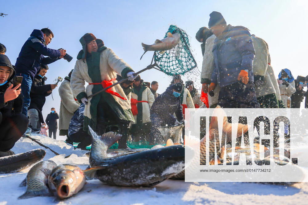 KW02 BAYINGOLIN, CHINA - JANUARY 15: Tourists watch fish caught by fishermen during winter fishing on frozen Bosten Lake on January 15, 2022 in Bayingolin Mongol Autonomous Prefecture, Xinjiang Uygur Autonomous Region of China.