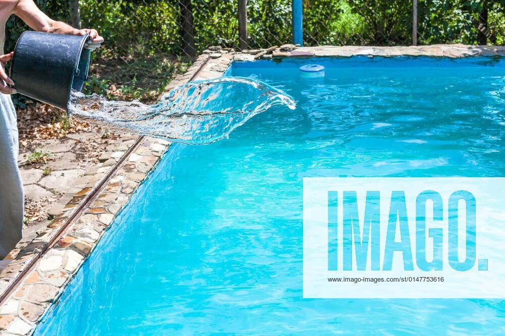 Man pours of disinfectant from bucket in pool model released, Symbolfoto, 12.10.2020,