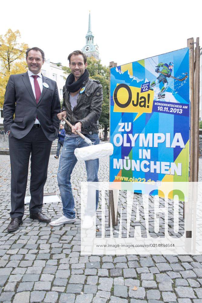 Plakataktion Buergerbegehren pro Olympia 2022, Rindermarkt, München. 22.12.2013 Thomas Muderlak, der Geschäftsführer der BMW Welt, Vorstandssprecher der Tourismus Initiative München, Mitbegründer des Team München 2022 und Sven Hannawald, Skispringer und Rennfahrer kleben Plakate Â
