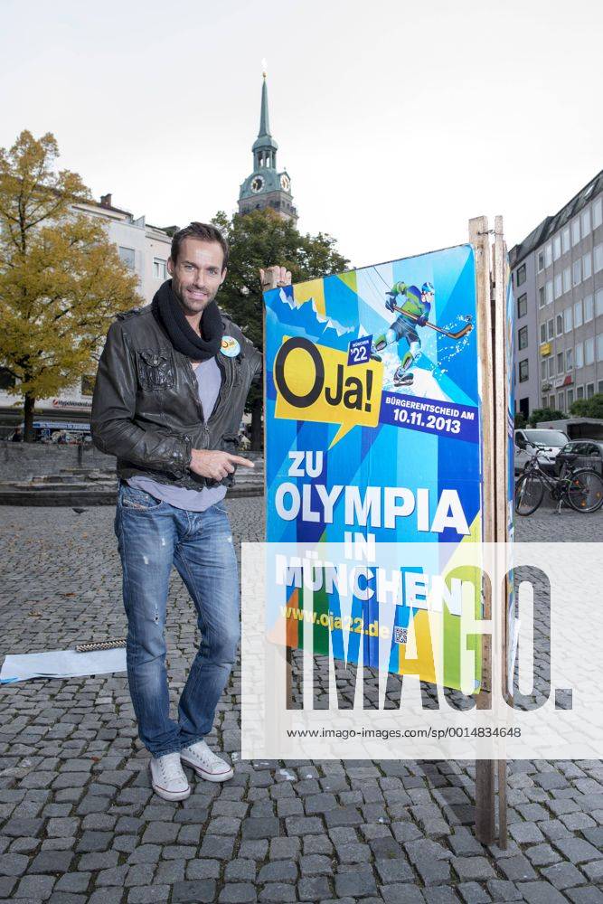 Plakataktion Buergerbegehren pro Olympia 2022, Rindermarkt, München. 22.12.2013 Thomas Muderlak, der Geschäftsführer der BMW Welt, Vorstandssprecher der Tourismus Initiative München, Mitbegründer des Team München 2022 und Sven Hannawald, Skispringer und Rennfahrer kleben Plakate Â