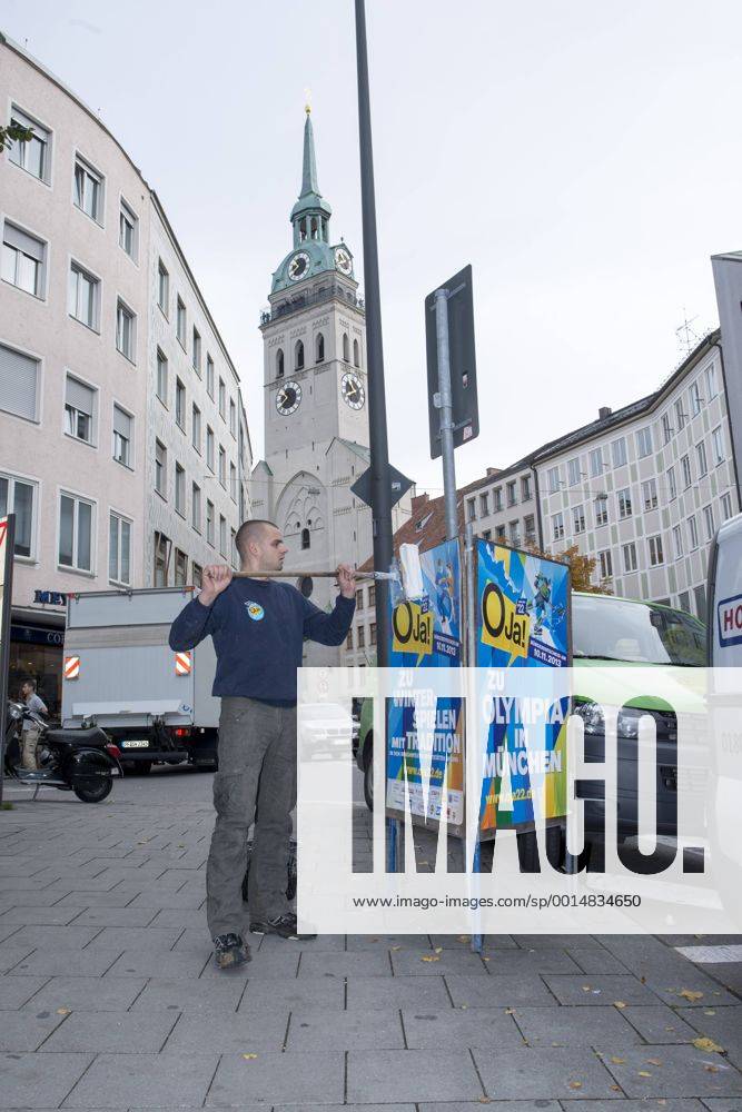 Plakataktion Buergerbegehren pro Olympia 2022, Rindermarkt, München. 22.12.2013 Thomas Muderlak, der Geschäftsführer der BMW Welt, Vorstandssprecher der Tourismus Initiative München, Mitbegründer des Team München 2022 und Sven Hannawald, Skispringer und Rennfahrer kleben Plakate Â