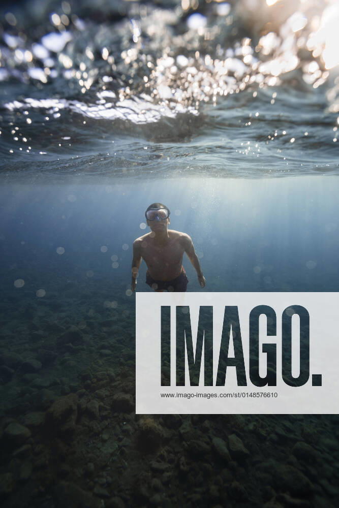 IMAGO Creative: Ende des Sommers Young man with goggles swimming underwater model released, RSGF00757