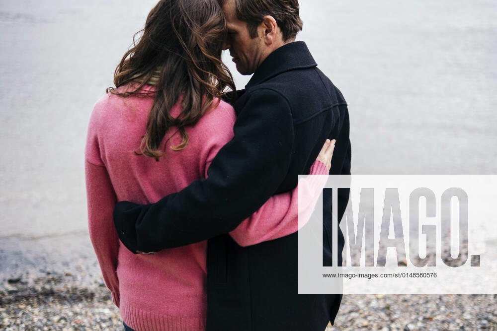 Couple embracing each other at Thames riverbank, London, England model released, AMWF00045