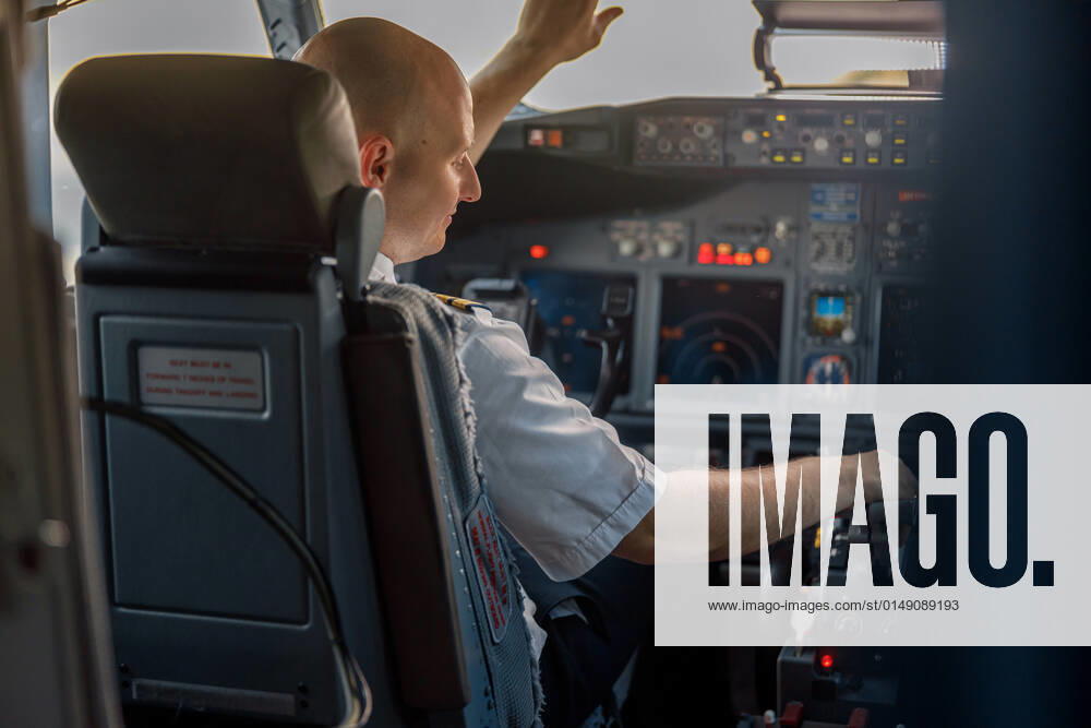 Focused professional pilot sitting in an airplane cabin, ready for takeoff Focused professional pilot sitting in an airplane cabin, ready for takeoff. Aircraft, aircrew, occupation concept
