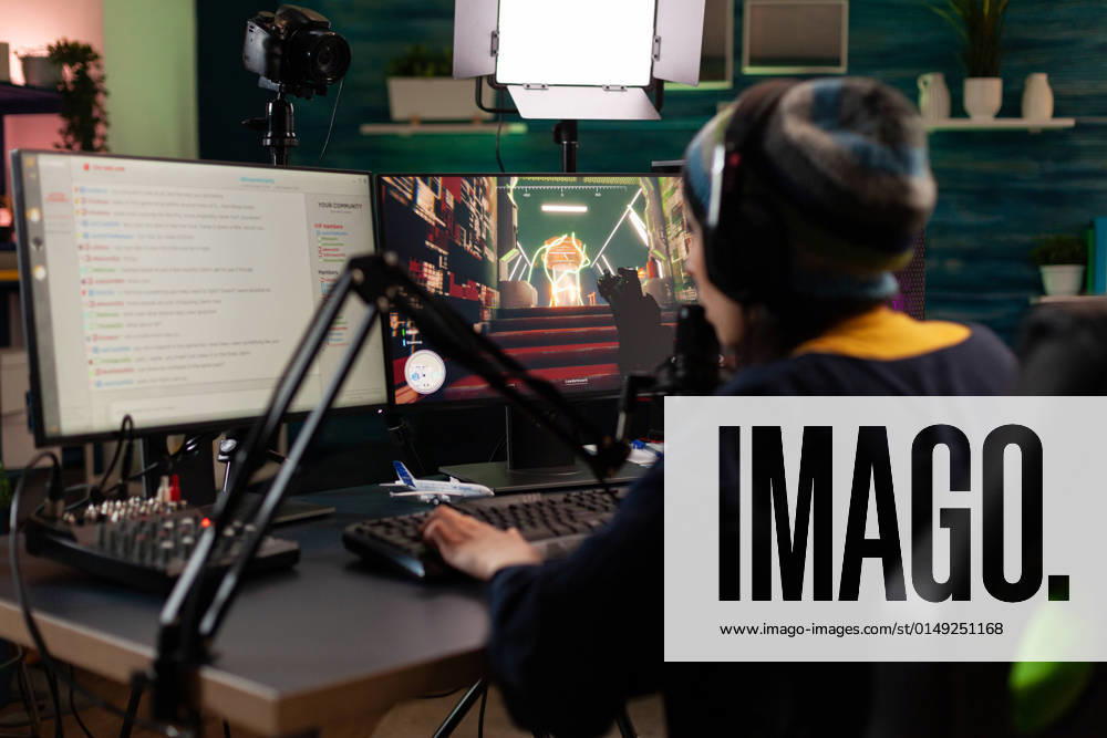 IMAGO Creative, Lifestyle, Gaming Player doing online live streaming with video games Player doing online live streaming with video games. Woman using gameplay on computer to stream and looking at monitor with chat. Person broadcasting and playing games with microphone.