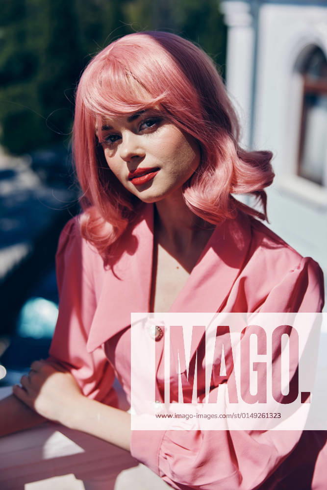 IMAGO Creative, Lifestyle, Barbiecore pretty woman Vintage fashion pink hair posing summer Happy female relaxing pretty woman Vintage fashion pink hair posing summer Happy female relaxing. High quality photo