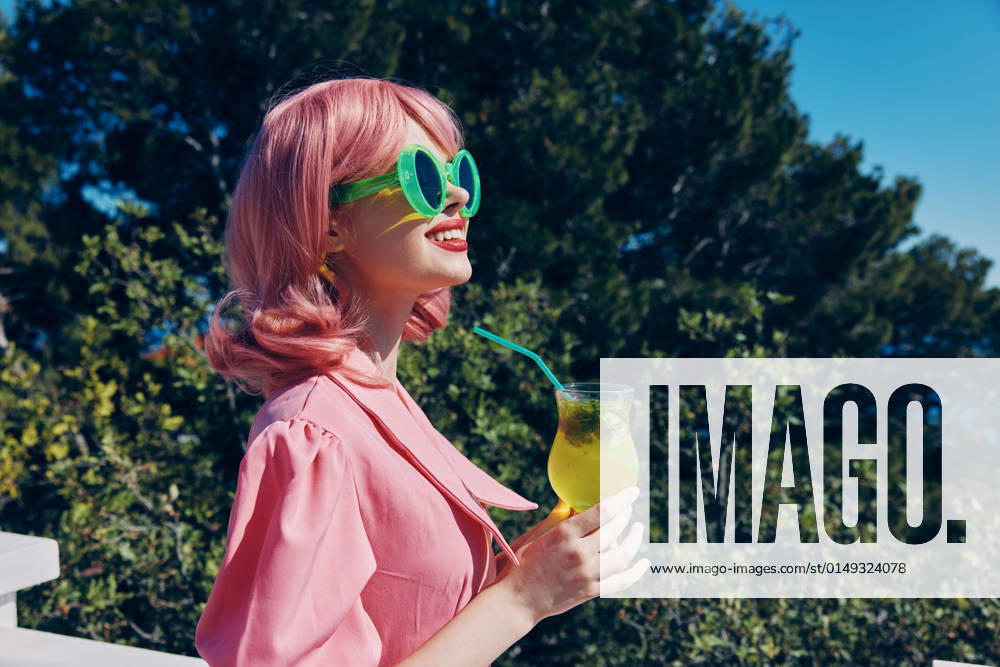 IMAGO Creative, Lifestyle, Barbiecore portrait of beautiful woman happiness vacation sunny summer cocktail Drinking alcohol portrait of beautiful woman happiness vacation sunny summer cocktail Drinking alcohol. High quality photo