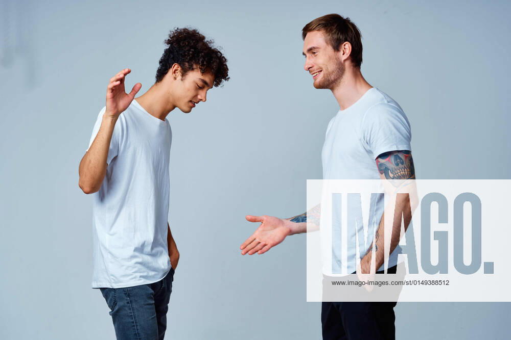 Two men in t-shirts friendship communication light background two men in t-shirts friendship communication light background. High quality photo