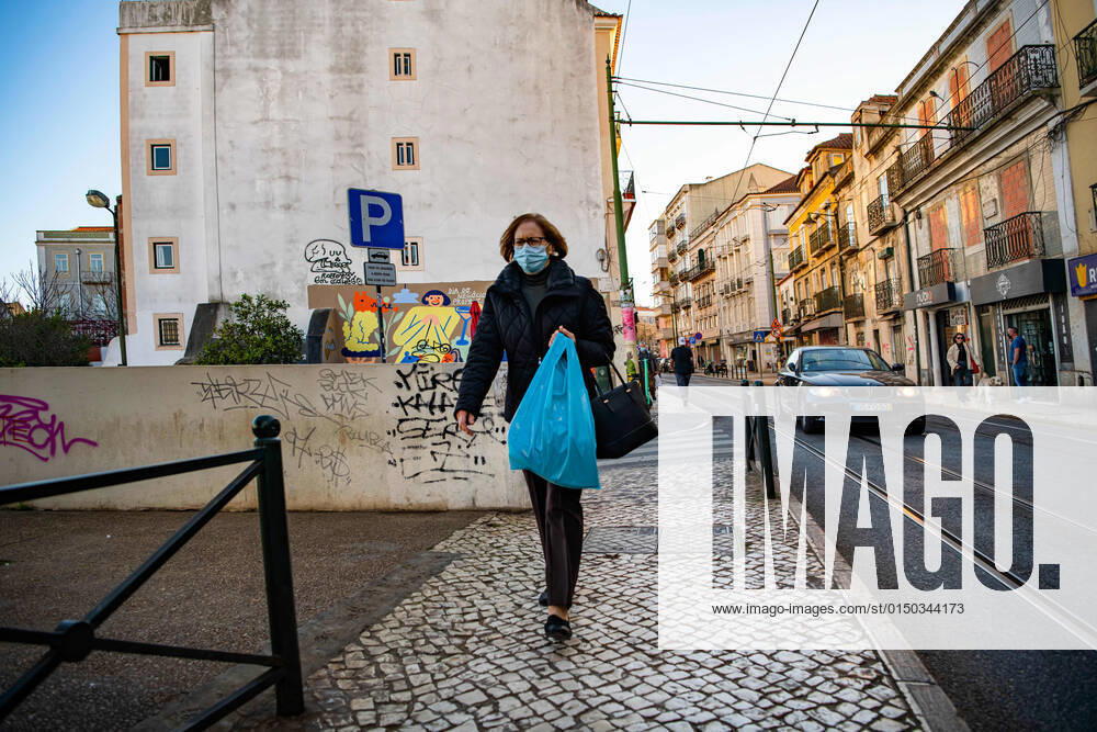 A woman wearing a face mask as a preventive measure against the spread of coronavirus walks along the street in the historic neighborhood of Graca, Lisbon. Portugal s official records include a total of 2,915,971 confirmed cases of COVID-19 and 20,222 fatalities since the beginning of the pandemic. Lisbon Portugal - ZUMAs197 20220207_zaa_s197_500