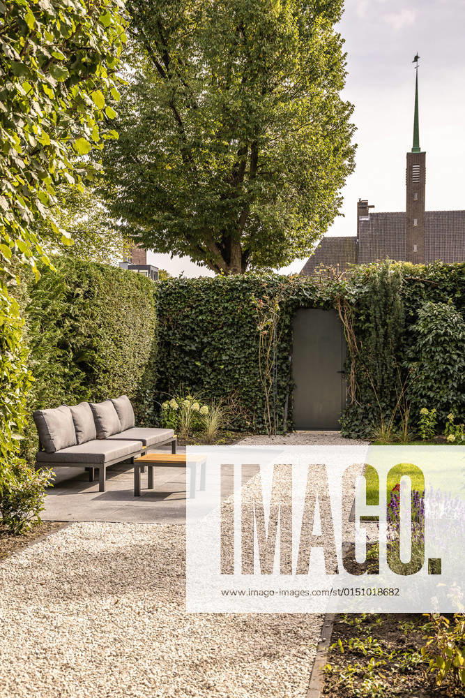Comfortable gray sofa placed near lush green trees on terrace with grassy lawn on sunny summer day in house garden, Property released CasaMedia_RichardWagnerstraat1_39.jpg