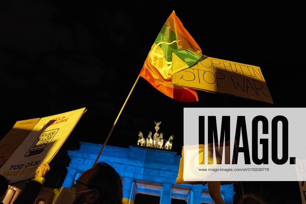 Brandenburger Tor leuchtet in ukrainischen Nationalfarben Europa, Deutschland, Berlin, 24.02.2022: Ukrainer protestieren vor dem Brandenburger Tor gegen den Einmarsch russischer Soldaten in der Ost-Ukraine. Präsident Putin hatte die von russischen Separatisten kontrollierten Regionen Donetsk und Luhansk als unabhängige Republiken anerkannt und zur Unterstützung russische Soldaten geschickt.