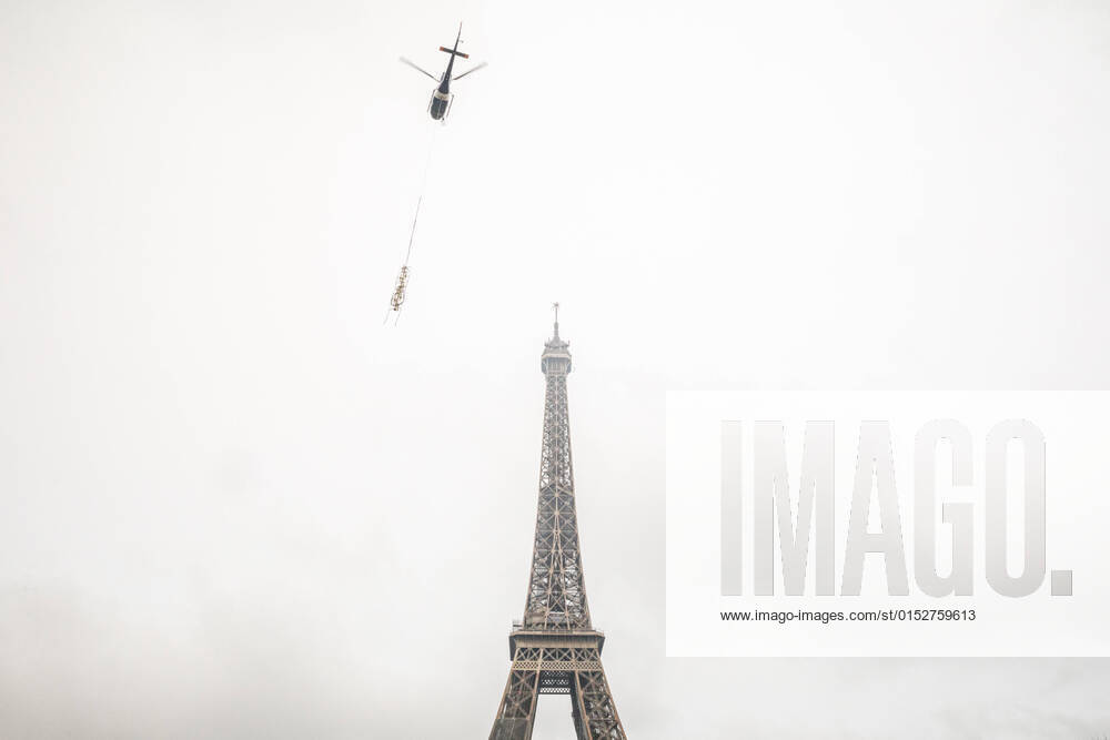 (220315) -- PARIS, March 15, 2022 -- A helicopter lifts a new antenna to the top of the Eiffel Tower in Paris, France, on March 15, 2022. The Eiffel Tower grew by six meters on Tuesday after a new radio antenna was installed on top of the Paris monument, to a height of 330 meters. (Photo by Xinhua) FRANCE-PARIS-EIFFEL TOWER-ANTENNA-INSTALLATION FlorentxMichel
