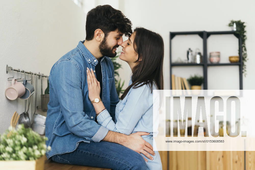 Happy young couple rubbing noses in kitchen model released property released, GIOF14880