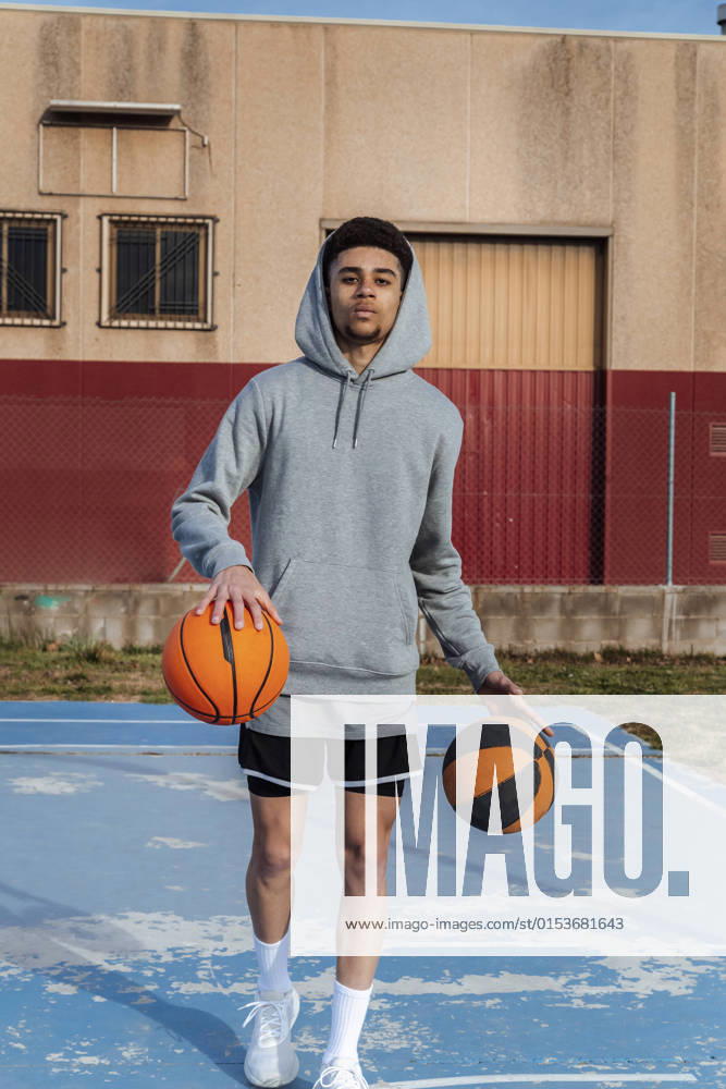 IMAGO Creative: 2022 Sport Favoriten IMAGO Creative: Sport in der Stadt Sportive Hispanic male in activewear looking at camera and dribbling balls while playing basketball on sports ground on summer day JordiCalvera_Basketball_15.jpg