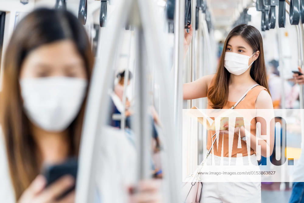Young Asian woman passenger wearing surgical mask and reading the book in subway train when traveling in big city at Covid19 outbreak, Infection and Pandemic concept, model released, , property released, , 33549576.jpg, avoid sick, train station, virus outbreak, tourist travel, subway train, 2020, bangkok thailand, respiratory, quarantine, protection, face, bts skytrain, environment, social distancing, crowned people, new normal, young woman, asian, business, cellphone, chinese, city, female, japanese, korean, china, metro, passenger, public, smartphone, southeast asian, transport, urban, commuting, journey, teenager, business on the go, earphone, covid19, coronavirus, 2019-ncov, disease, influenza, pandemic, air pollution, surgical mask, h