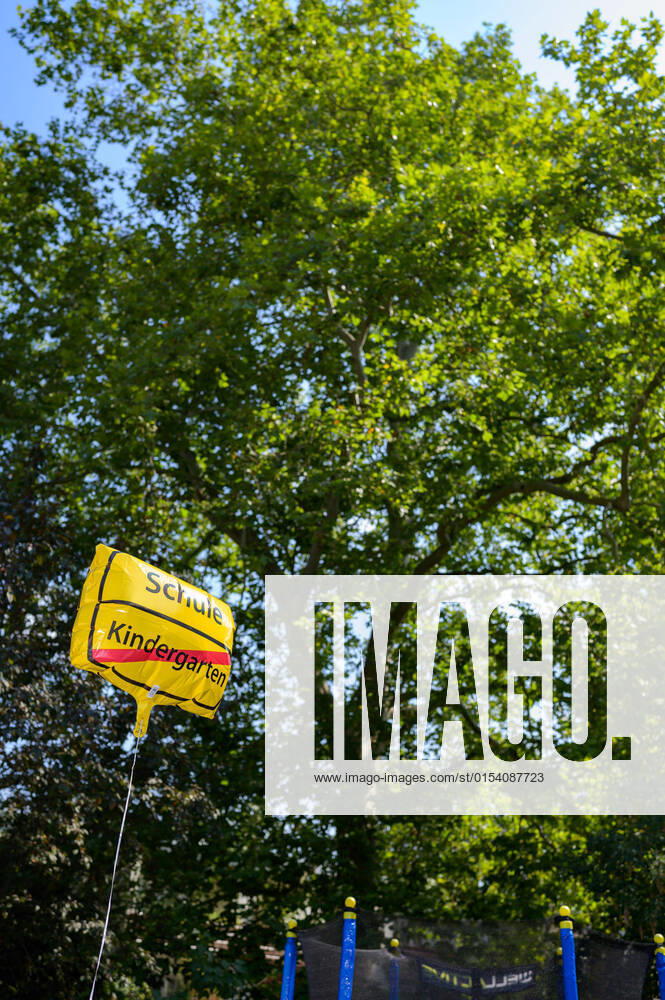 IMAGO Creative: Gesellschaft, Schule, Schulanfang An einer Schnur ist ein Luftballon befestigt. Auf dem Ballon steht Schule und durchgestrichen Kindergarten . Der Luftballon sieht aus wie ein Ortsschild.