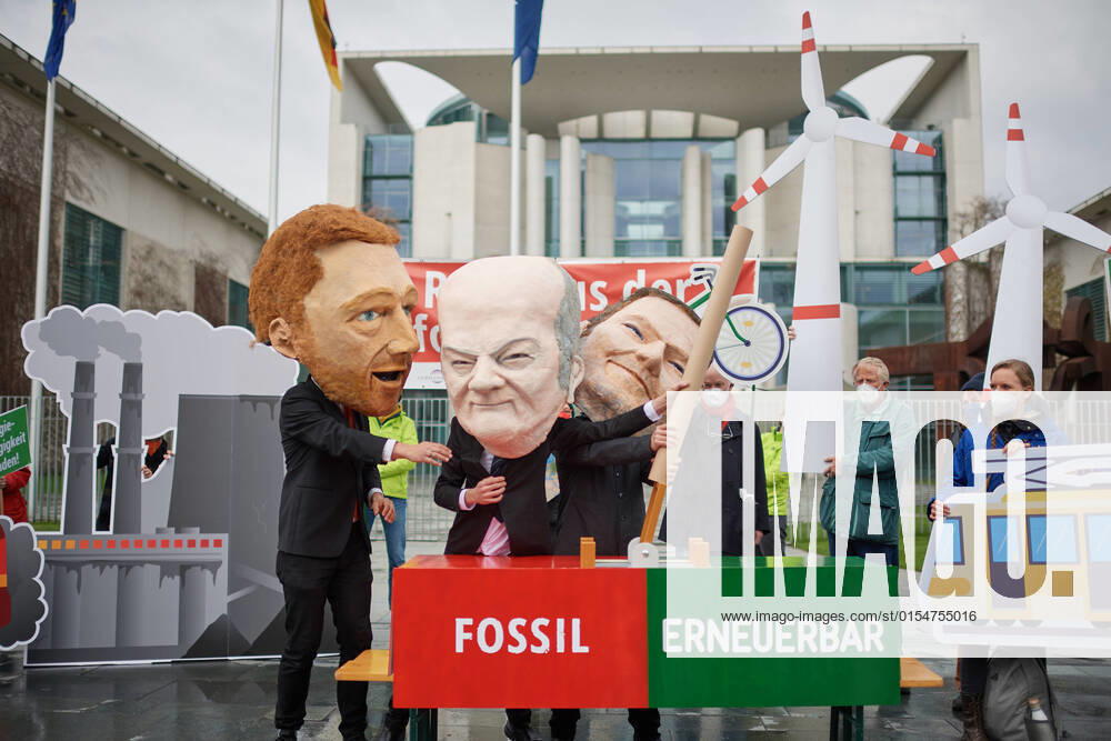 Vor dem Kanzleramt in Berlin legten Kundgebungsteilnehmer mit Grossmasken von Bundeskanzler Olaf Scholz, Bundesfinanzminister Christian Lindner und Bundeswirtschaftsminister Robert Habeck, einen Schalter von fossilen auf Erneuerbare Energien um (Foto vom 06.04.2022). BUND, Campact, DNR, DUH, Germanwatch, Nabu und WWF fordern angesichts der aktuellen Energiekrise ein umfangreiches Investitions- und Massnahmenpaket fuer die Energiewende. Die von der Bundesregierung bisher geplanten Entscheidungen reichen dem Buendnis zufolge nicht aus, um die Abhaengigkeit von fossilen Energietraegern zu beenden. (Siehe epd-Meldung vom 06.04.2022)
