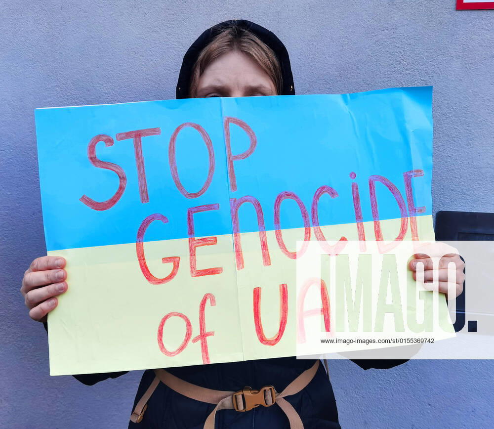 A demonstrator holds a sign stating Stop Genocide of UA during a protest over atrocities committed by the Russian military in Bucha and the missile attack on the Kramatorsk train station. Ukrainians, refugees, Germans, and people from around the world stood together to demand a stop to Russia s military aggression and for Europe to fortify Ukraine s defensed. Munich Germany - ZUMAb160 20220409_zbp_b160_005