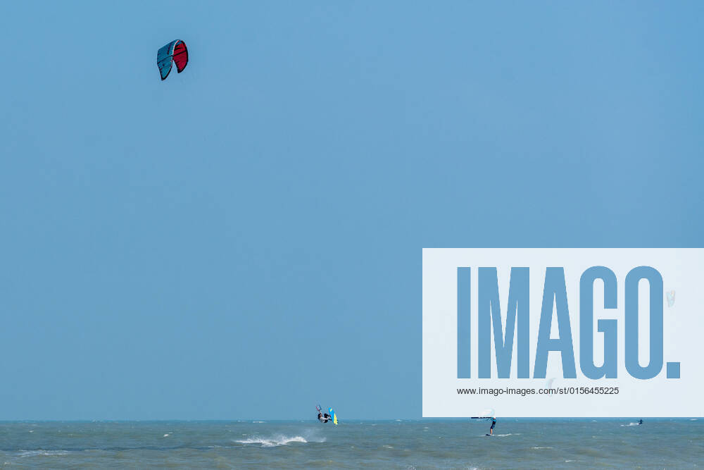 IMAGO Creative: Sommer Sport - Strand A kite surfer jumps out of the water while kiting in the Gulf of Mexico at South Padre Island, Texas. Other kite surfers and a wing surfer are nearby. South Padre Island Texas United States