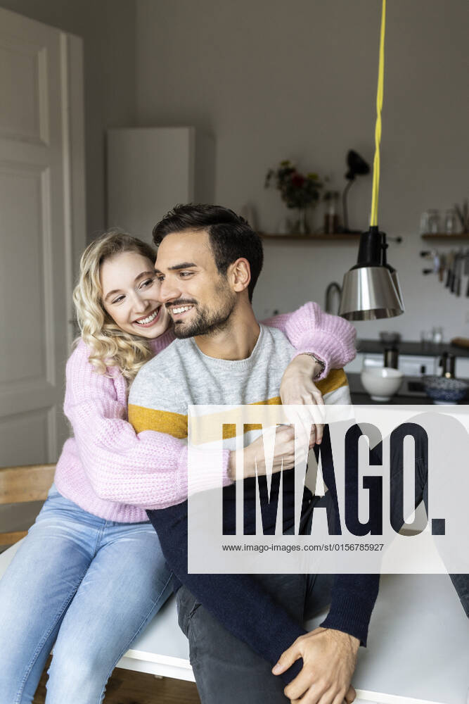 Smiling girlfriend embracing boyfriend at home model released, Symbolfoto property released, PESF03574
